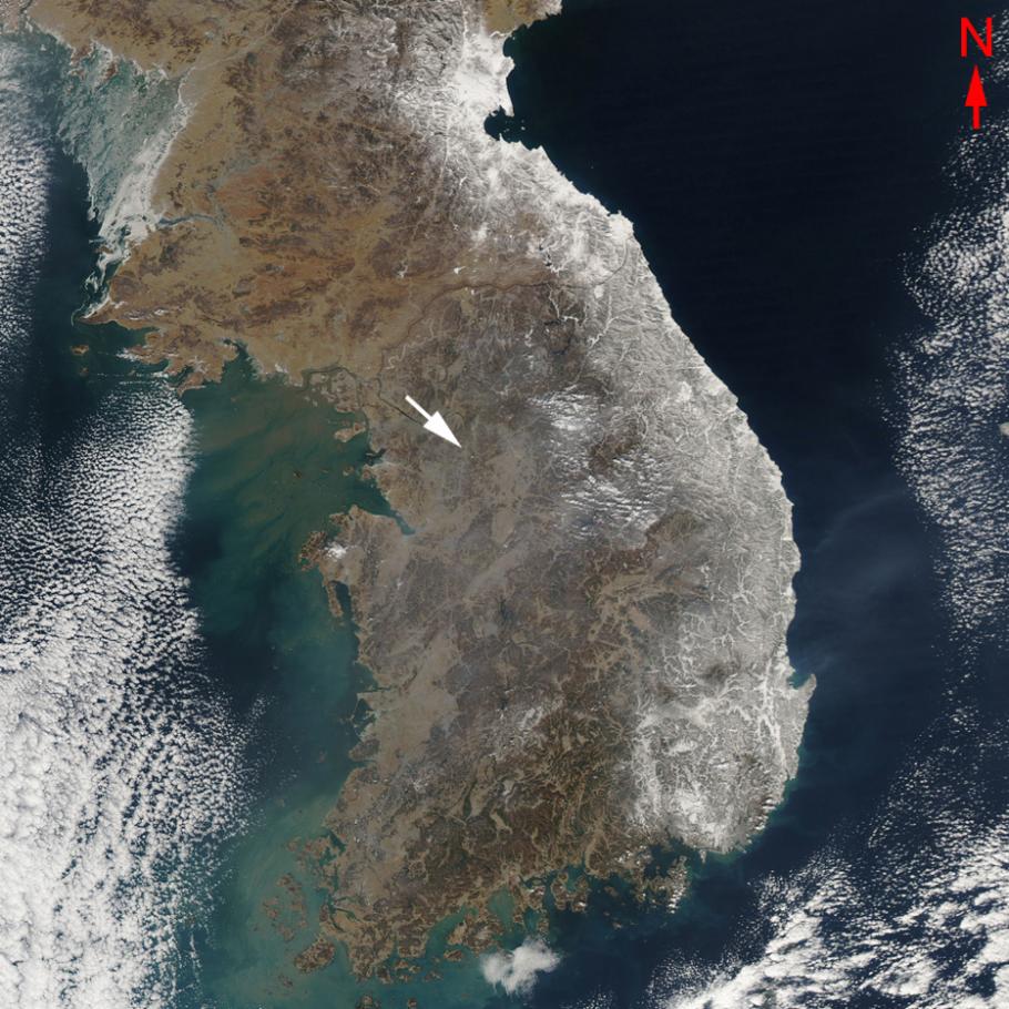 Satellite image of the Korean Peninsula with an arrow pointing to a city in the middle.