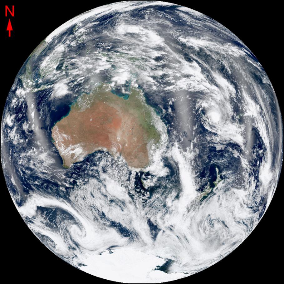 Satellite image of the earth with a land mass shown under swirling clouds.