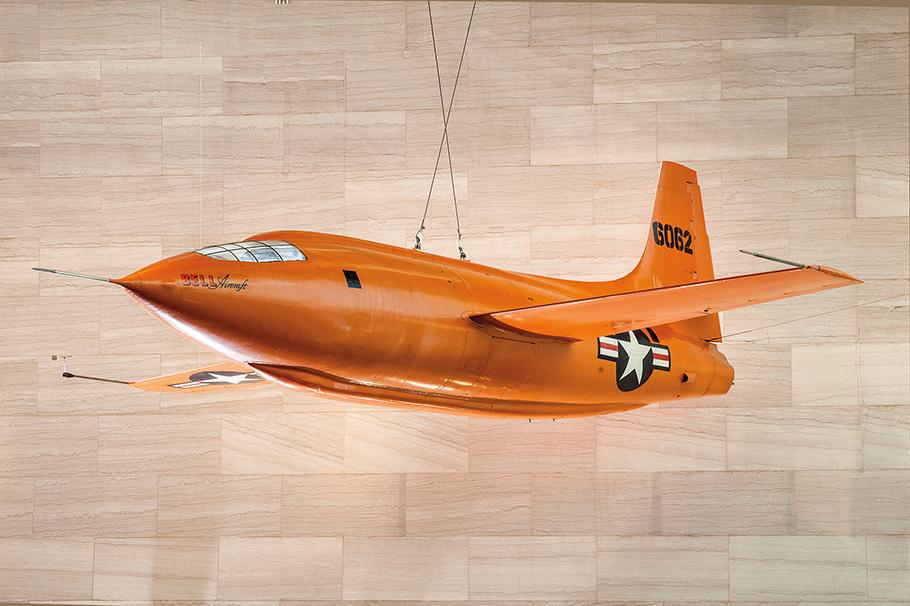 One-half right front view of Bell X-1 (s/n AF6062) on display in the Milestones of Flight Gallery at the National Air and Space Museum's National Mall building. The X-1’s bullet-shape fuselage is painted orange and wears U.S. Air Force markings.