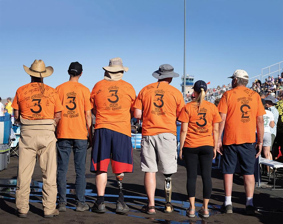 A group of fans, who call themselves "Section 3," stand together wearing orange t-shirts with the number 3 emblazoned on their backs.