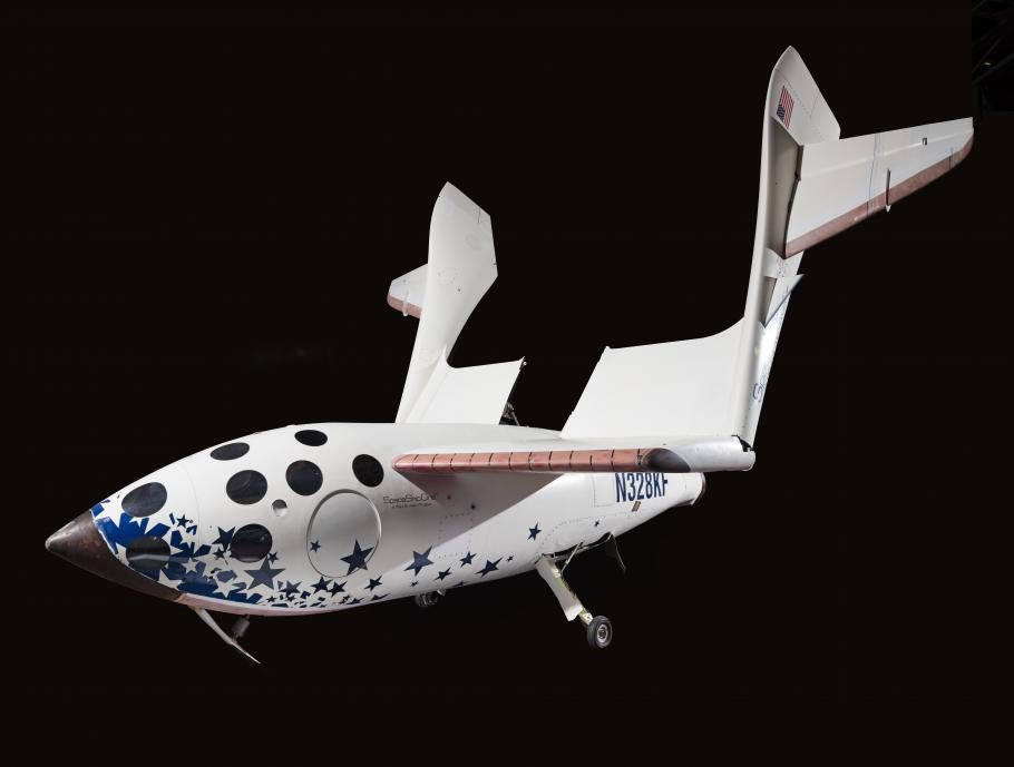 An airplane shaped space ship with circular windows at the front and blue stars on the "belly" of the ship. 