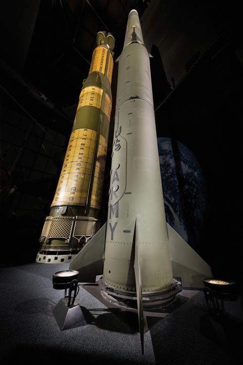 Two missile, a Soviet SS‑20 and a U.S. Army Pershing II on display with black background.