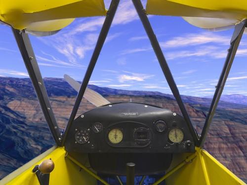 Panoramic photograph of the Piper J-3 Cub cockpit against a blue sky backdrop