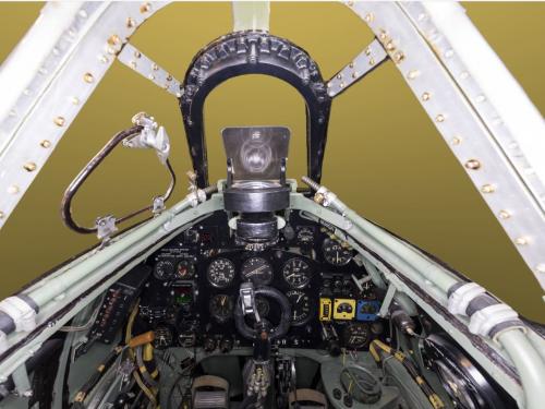 Cockpit view of a World War II aircraft with white metal frame supporting the aircraft.