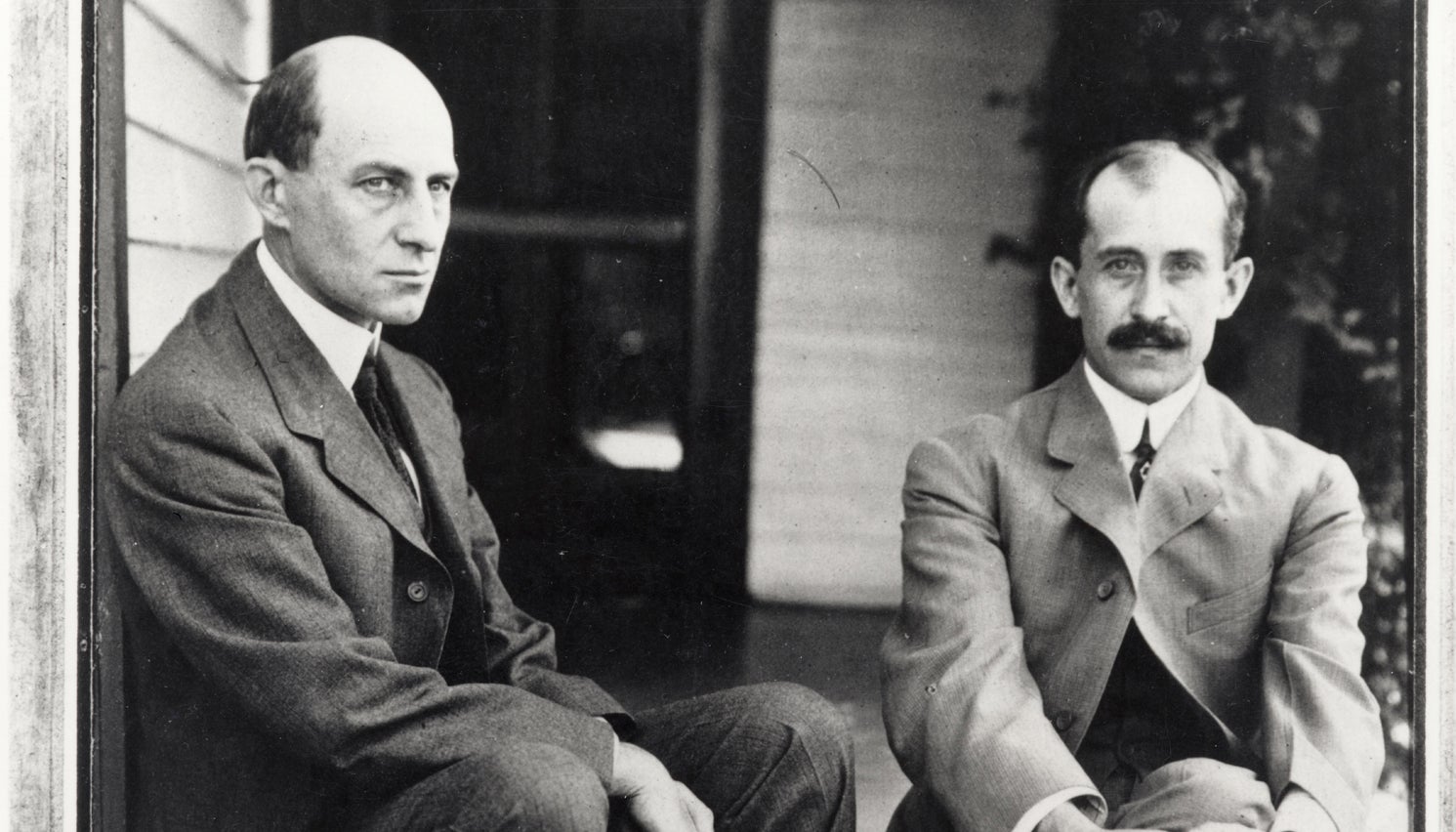 Portrait of Wilbur and Orville Wright seated outside