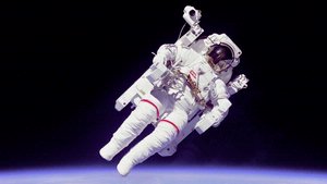 Bruce McCandless in space suit floating away from spacecraft.