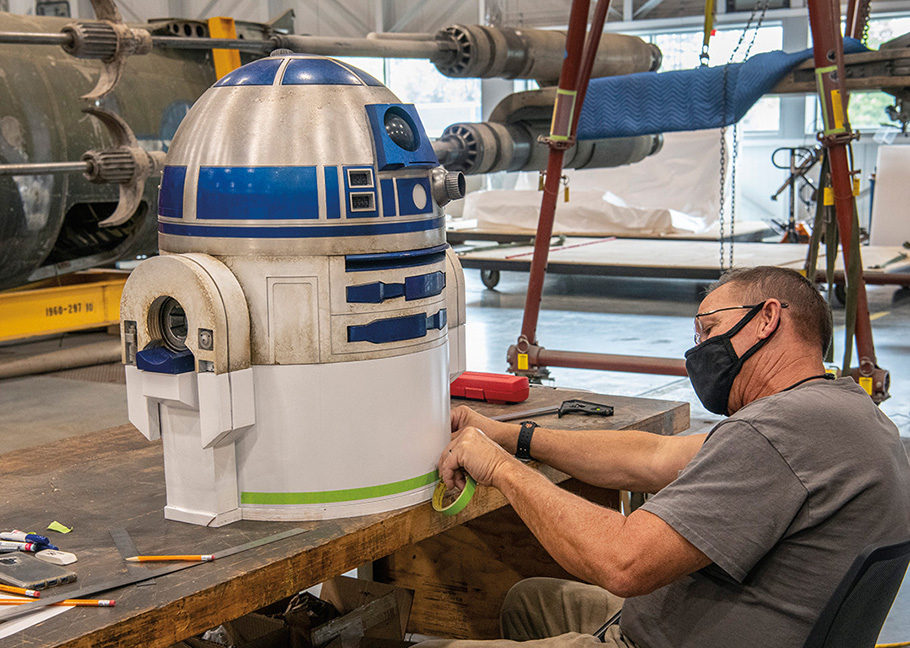 Museum Specialist Matt Voight preparing to paint the adapter he built for the model R2-D2 for the Star Wars Full Scale Prop X-Wing in the Mary Baker Engen Restoration Hangar at the  Steven F. Udvar-Hazy Center in Chantilly, VA.