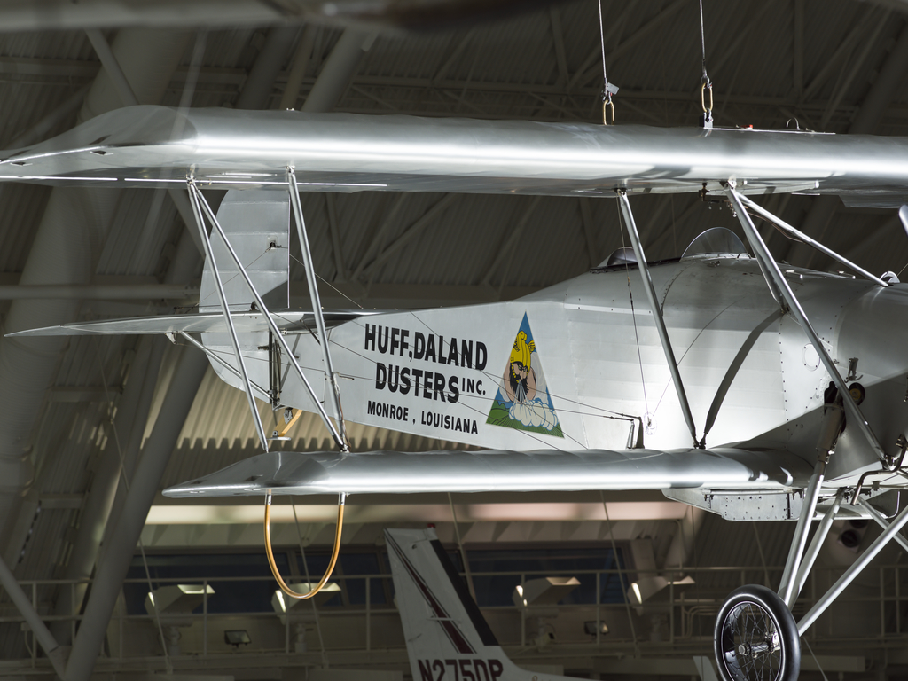 Silver painted fuselage of a biplane. Huff-Daland Duster is painted on the side of the plane.