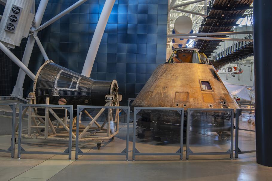 Two capsules that traveled in space, one larger than the other. Both are conically shaped.