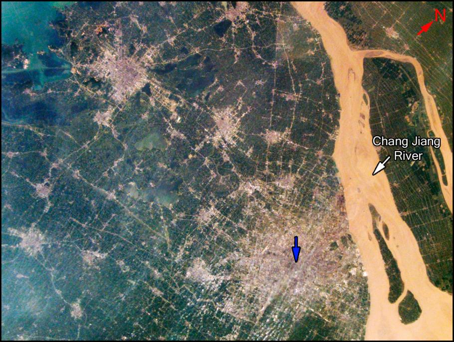 A blue arrow points to a satellite image of a city along the Chang Jiang River. 