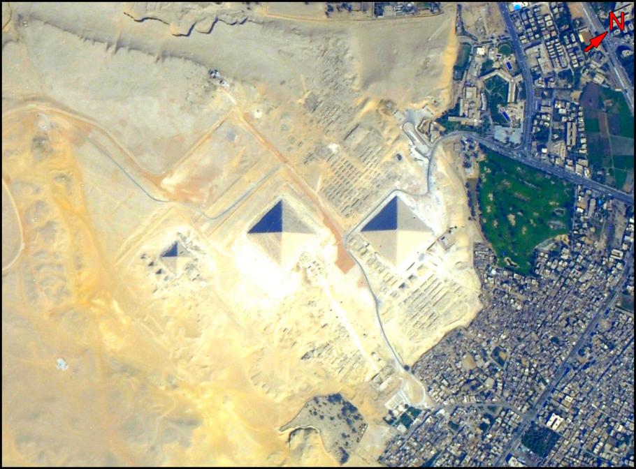 Satellite image of pyramids with a city to the left side.