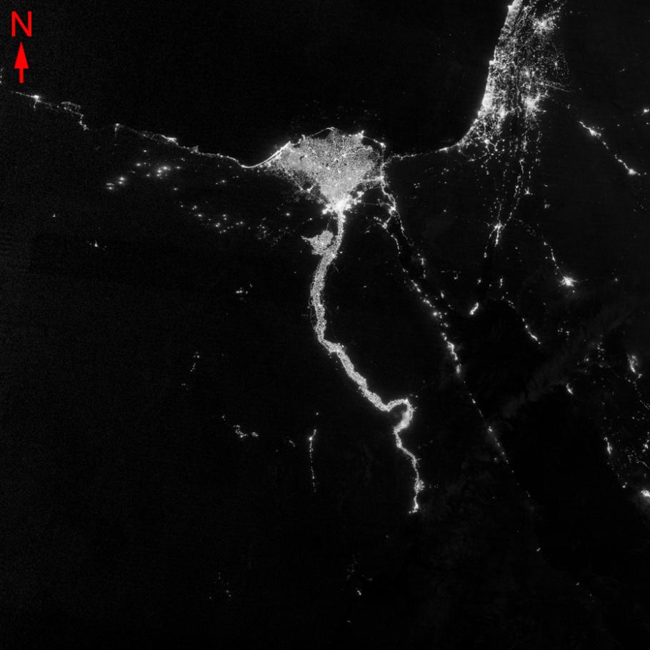 Satellite image of a river at night that opens up into the Mediterranean Sea. 