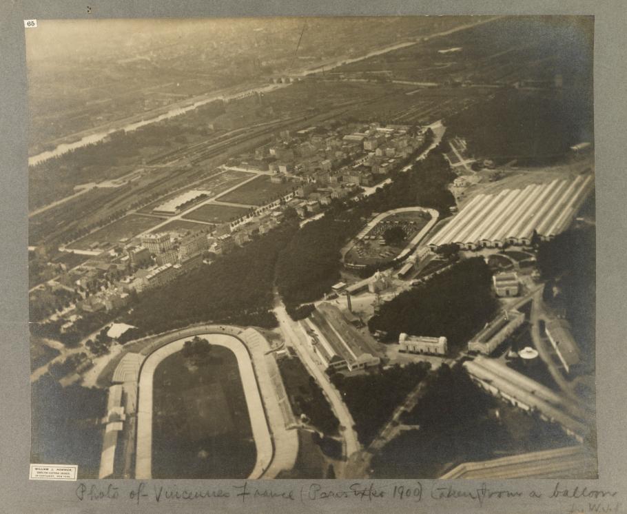 Black and White aerial photograph of city, elliptical race track in lower left corner