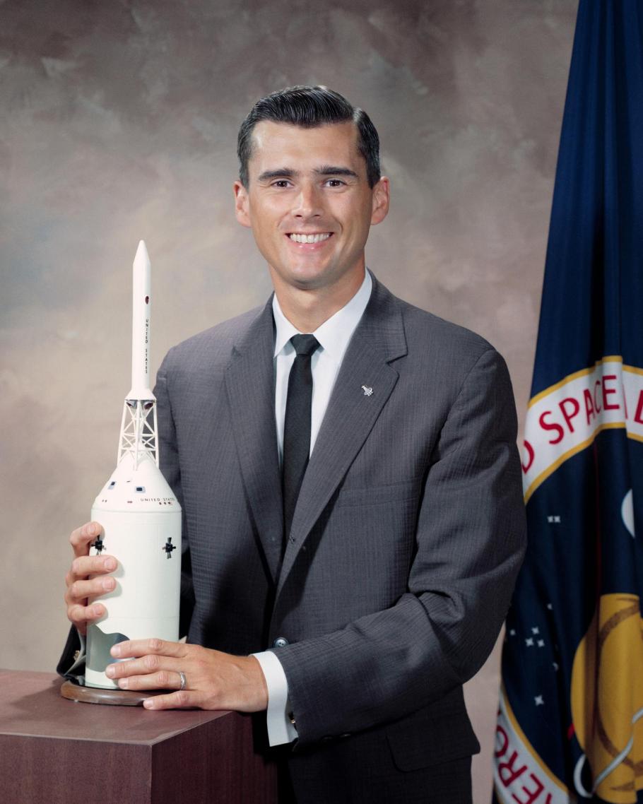 A color photographed portrait of Roger B. Chaffee holding a model of a rocket.