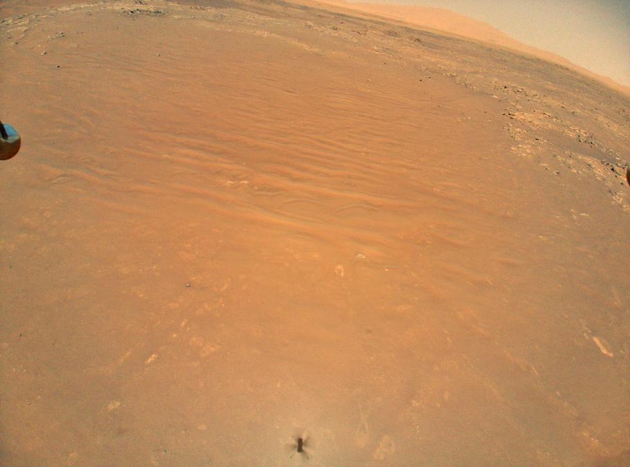 An image of the orange surface of Mars seen from the perspective of the Ingenuity helicopter.