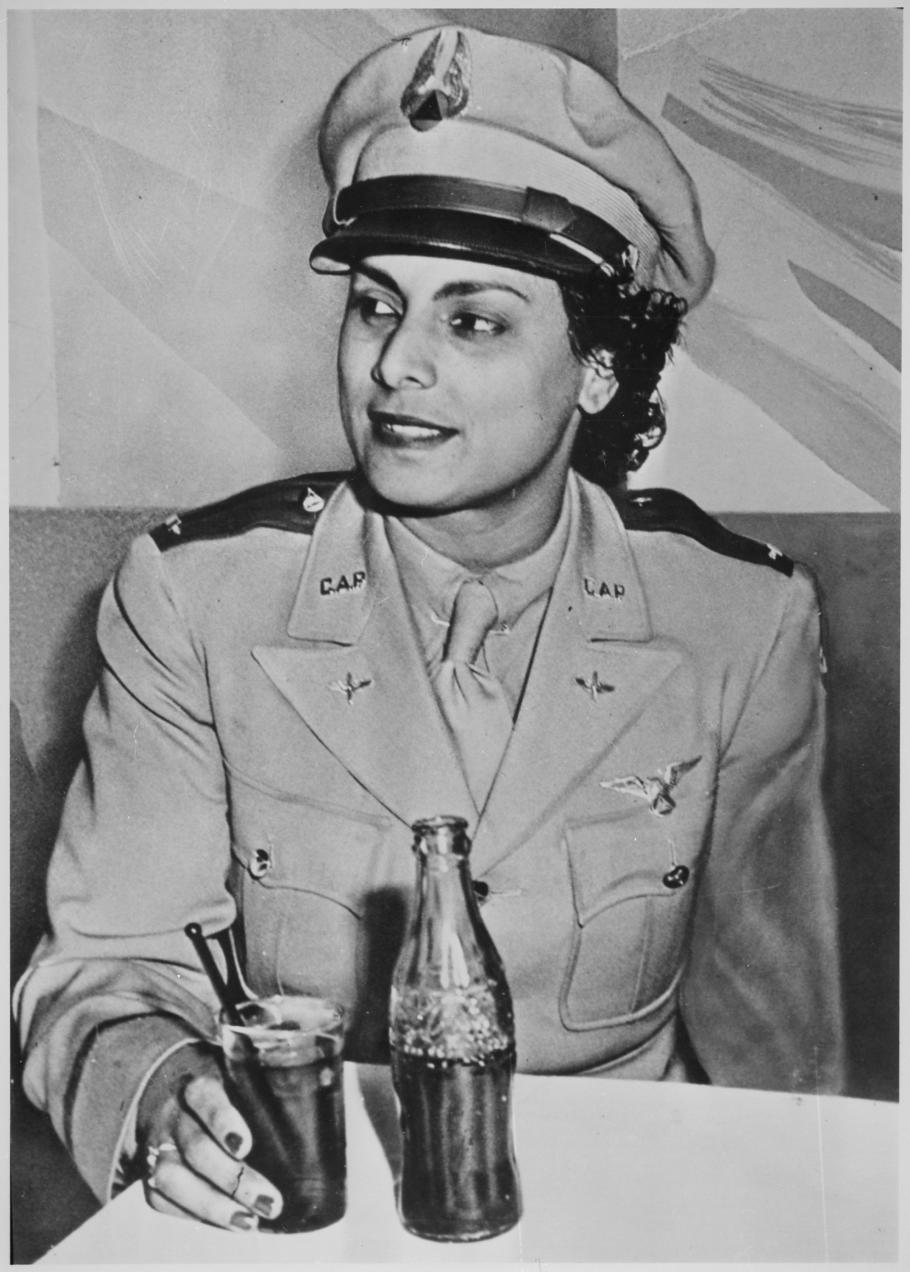 A woman in CAP uniform sits drinking a Coke.