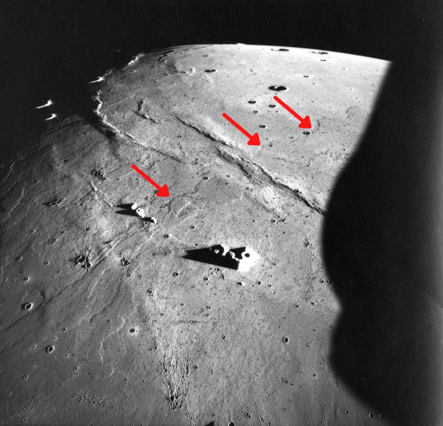 A photo of basalt flows on the Moon. Red arrows point to the flows, which form a line from the bottom left to the top right.