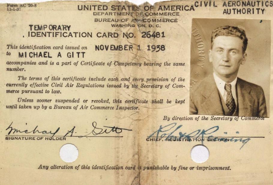 Card, ripped at the top with two holes punched in the bottom.  Text at top: United States Department of Commerce, Civil Aeronautics Authority. Small vertical photo in the upper right hand corner: White man with medium colored tousled hair wearing a suit and tie. Two signatures at the bottom: (left) Michael A. Gitt (Right) Robert K. Reining