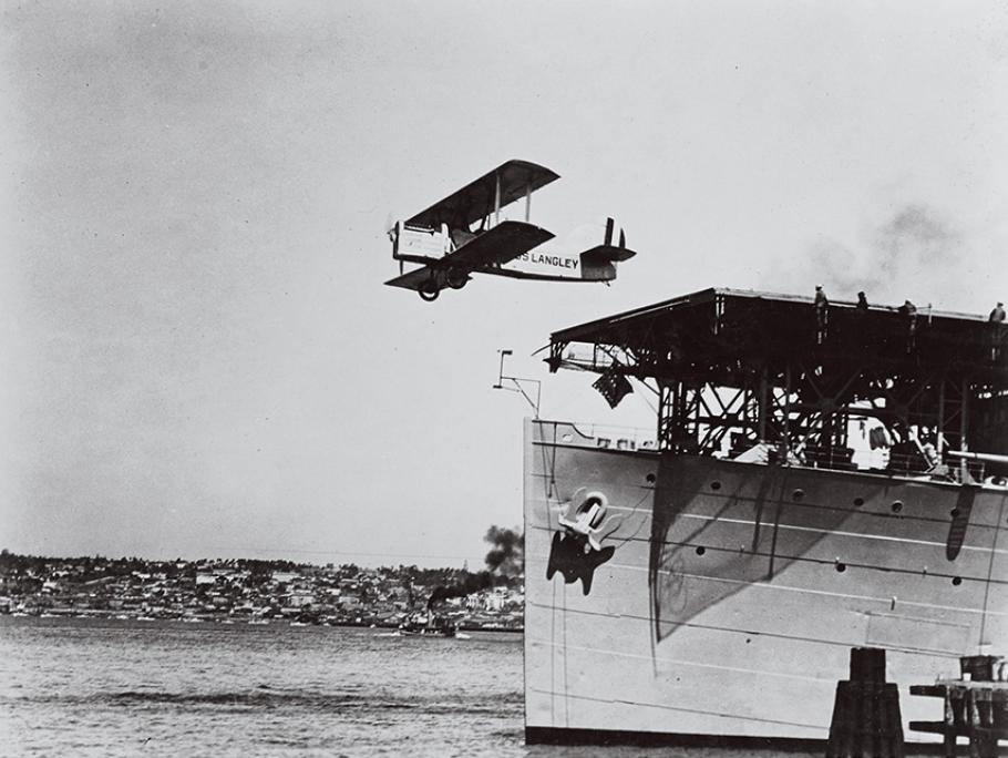 Biplane takes off form the bow of the USS Langley