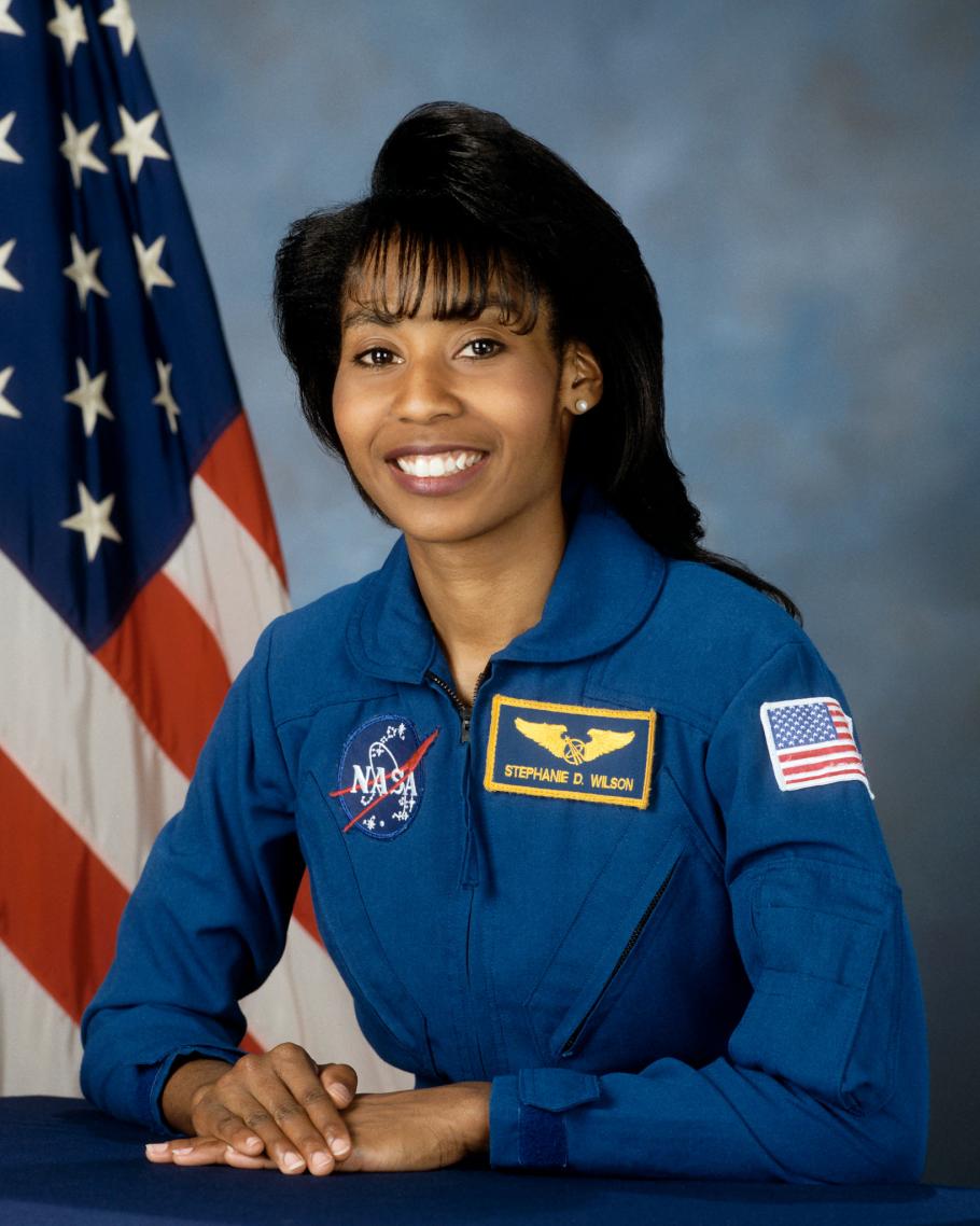 Stephanie Wilson smiles for a medium-shot portrait photo, wearing a blue jacket.