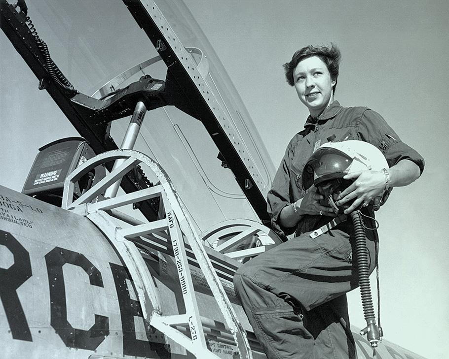 Portrait of Pilot Wally Funk on access ladder holding her helmet.