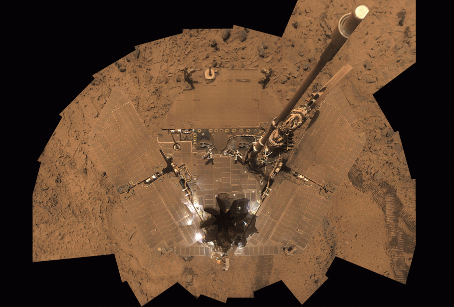 Overhead view of the Martian rover Spirit covered in dust.