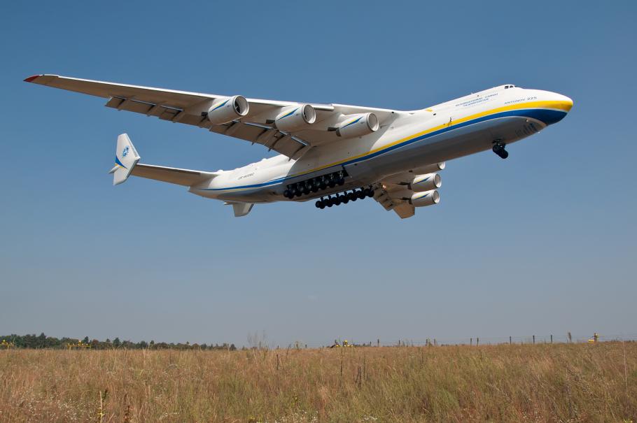 Large white aircraft with blue and yellow features lands 