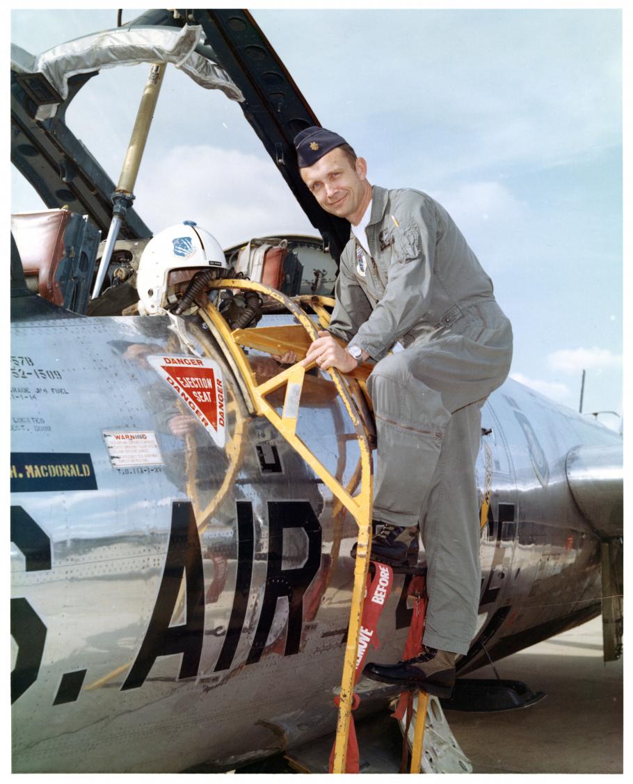 US Air Force Major Robert C. Mikesh poses standing on access ladder of Martin B-57B Canberra on the ground at Griffiss Air Force Base