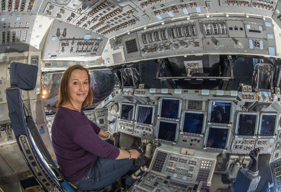 Curator Jennifer Levasseur sits in the cockpit of Space Shuttle Discovery.