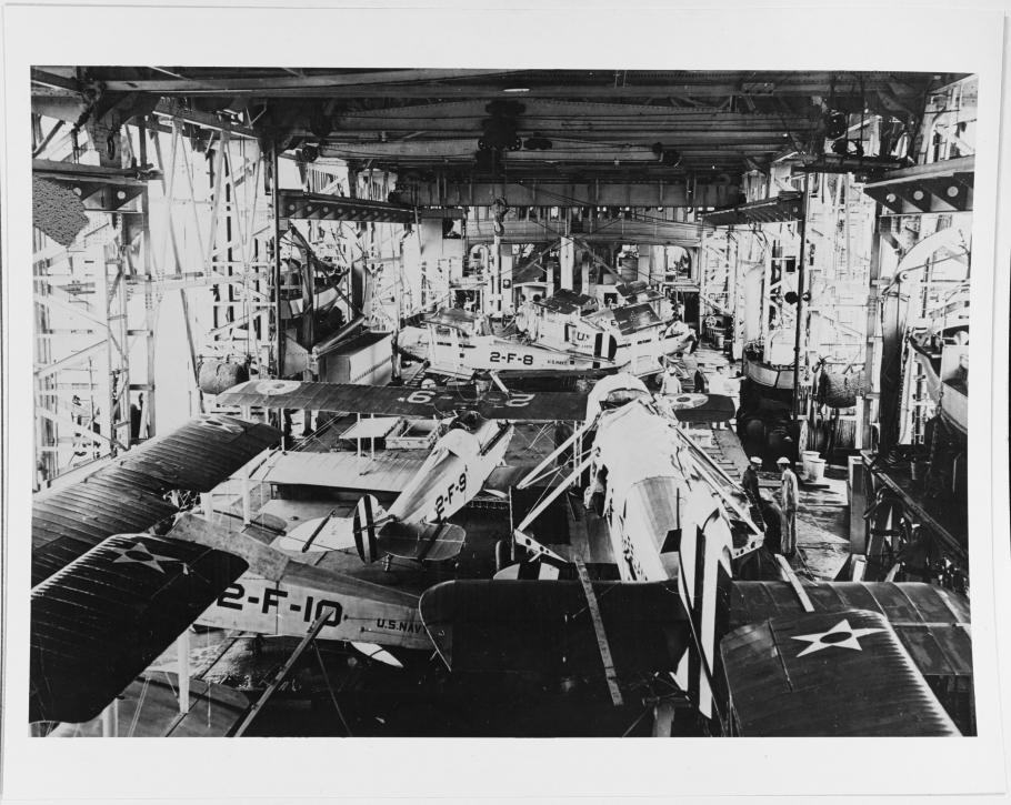 Black and white grainy image of numerous aircraft stored on a aircraft carrier