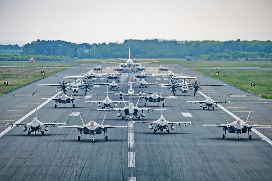 More than two dozen military aircraft are lined up, side by side, on the tarmac at Misawa Air Base, including U.S. Air Force F-16CMs and a U.S. Navy EA-18G Growler.
