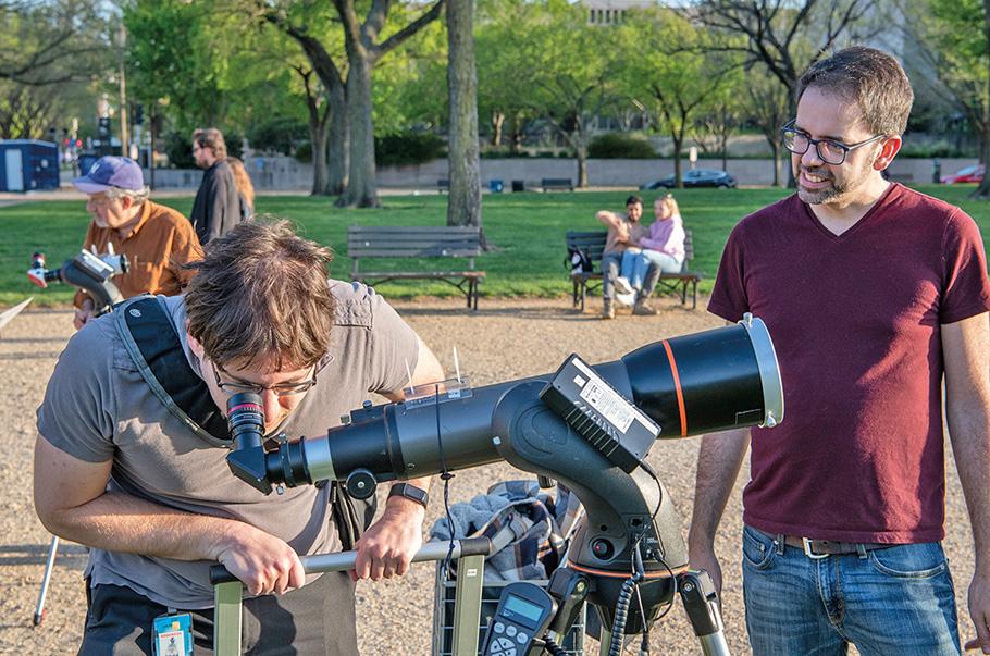 On a sunny, summer day on the National Mall, two men take turns looking through a telescope that has been set up for the Museum’s pop-up astronomy event.