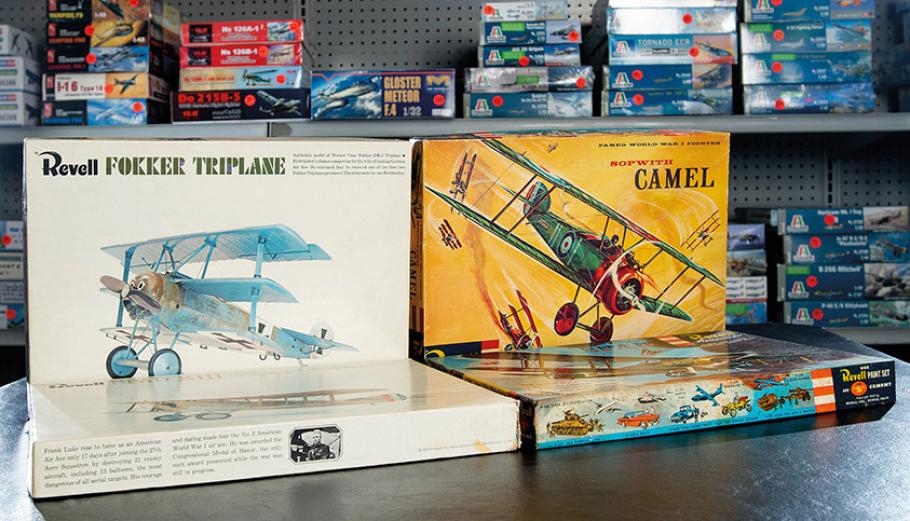 A Revell Fokker Triplane and Sopwith Camel plastic airplane kits sit on a table.