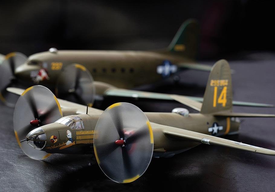 A meticulously detailed model of a B-26 Marauder sits on a table. The two propellers have been crafted to create the illusion that they are spinning.
