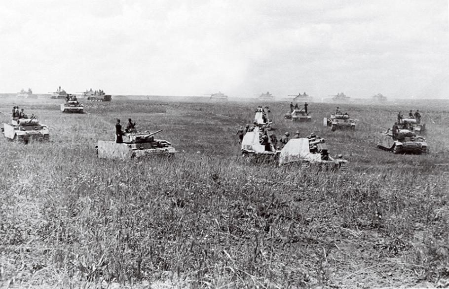 Several German tanks and heavy artillery menacingly cross an open field in 1943.