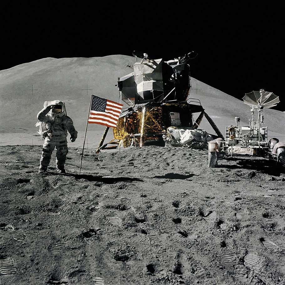 Apollo 15 astronaut Jim Irwin salutes the American flag while standing in front of the lunar lander on the bleak surface of the moon.