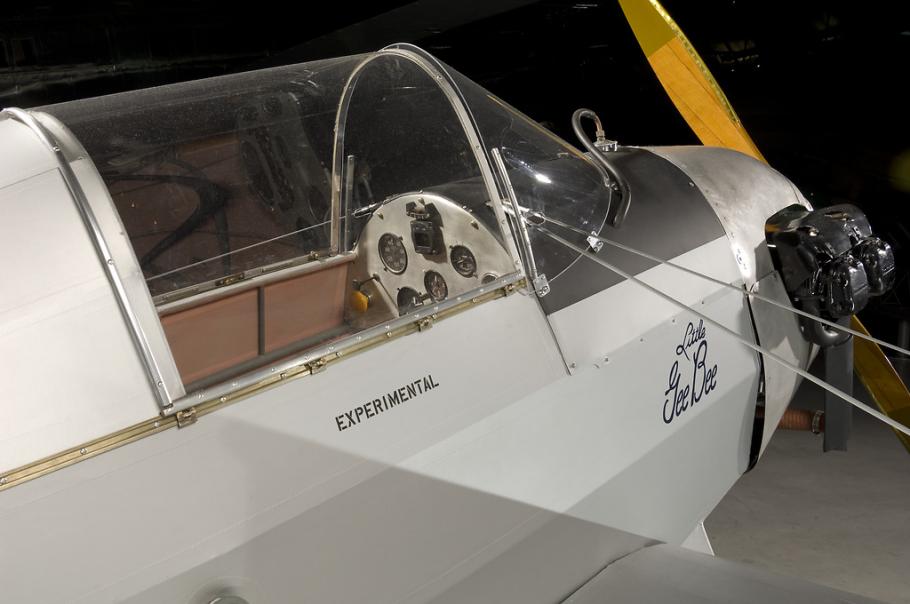A side view of front half of a gray colored prop plane. Written under the cockpit window is "experimental."