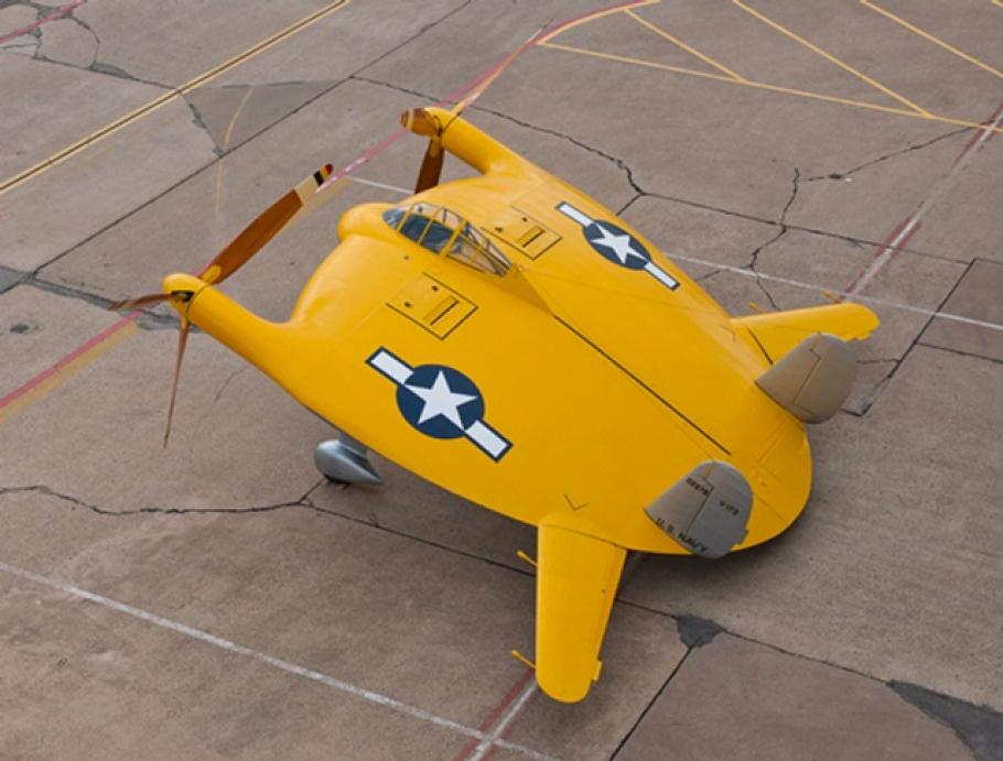 A yellow aircraft shaped like a disk with two propellers emerging from one side, and two wings emerging from the other. 