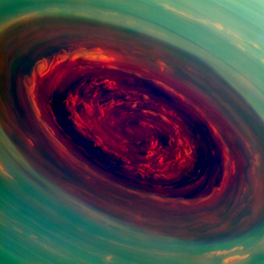 A circular vortex with dark and bright reds at the center surrounded by a light green-blue on its edges.