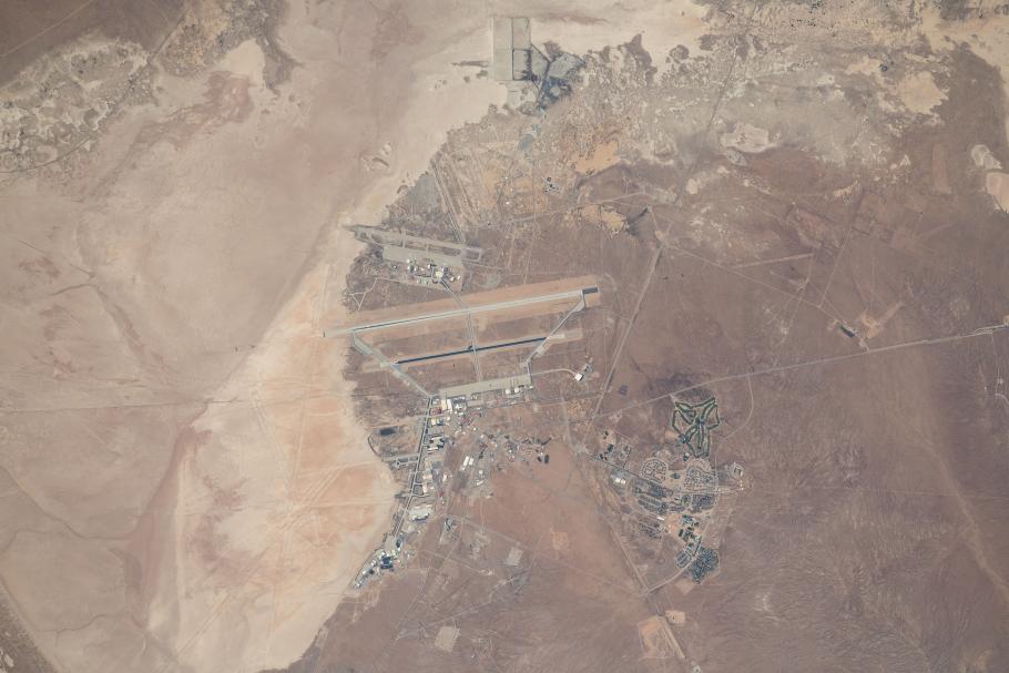 An aerial satellite image of a desert landscape with what looks like various structures in the middle.