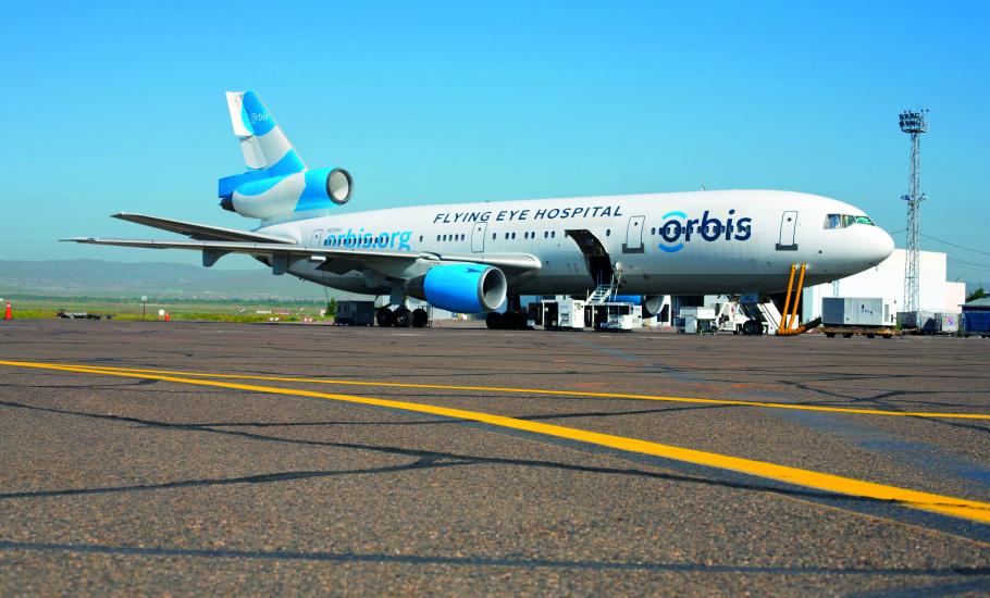A DC-10 jet airliner parked on an airport runway. It is covered in the orbis logo and says flying eye hospital on the side.