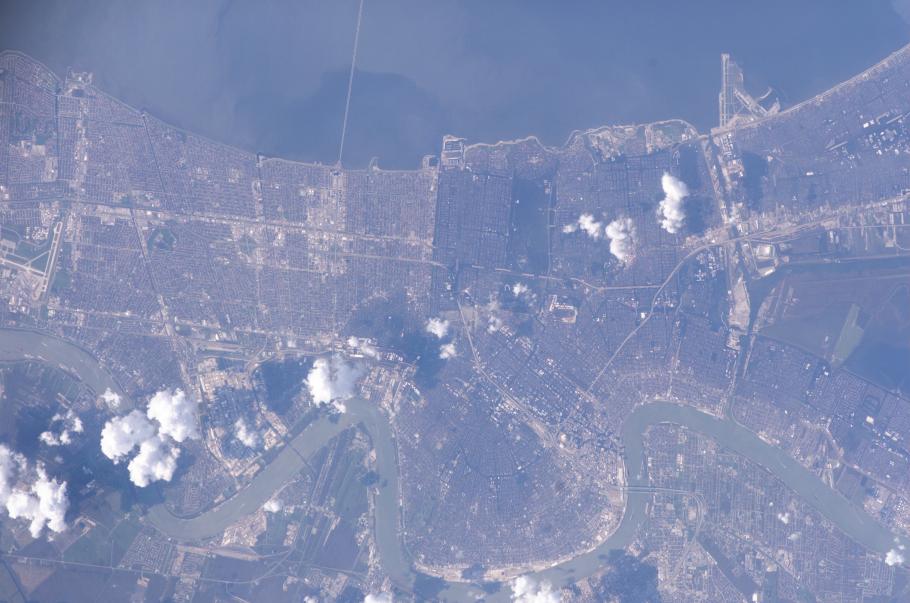 A satellite image of New Orleans. Puffs of smoke rise from the ground.