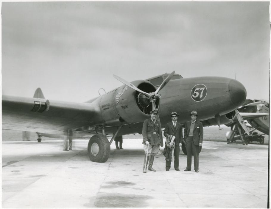 One-half right front view of the Boeing 247D with three men posing in front.