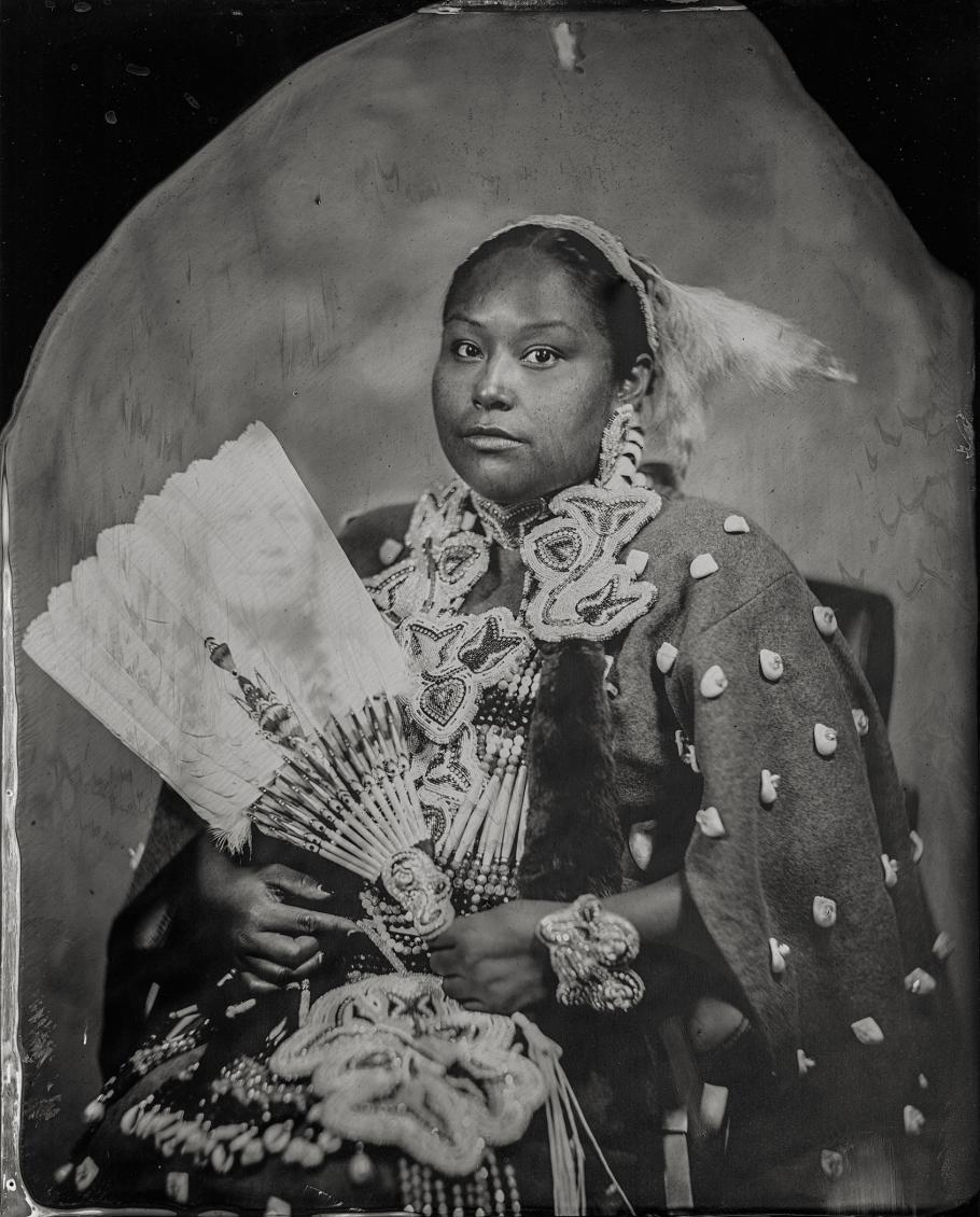A woman poses for a portrait in traditional Navajo attire.