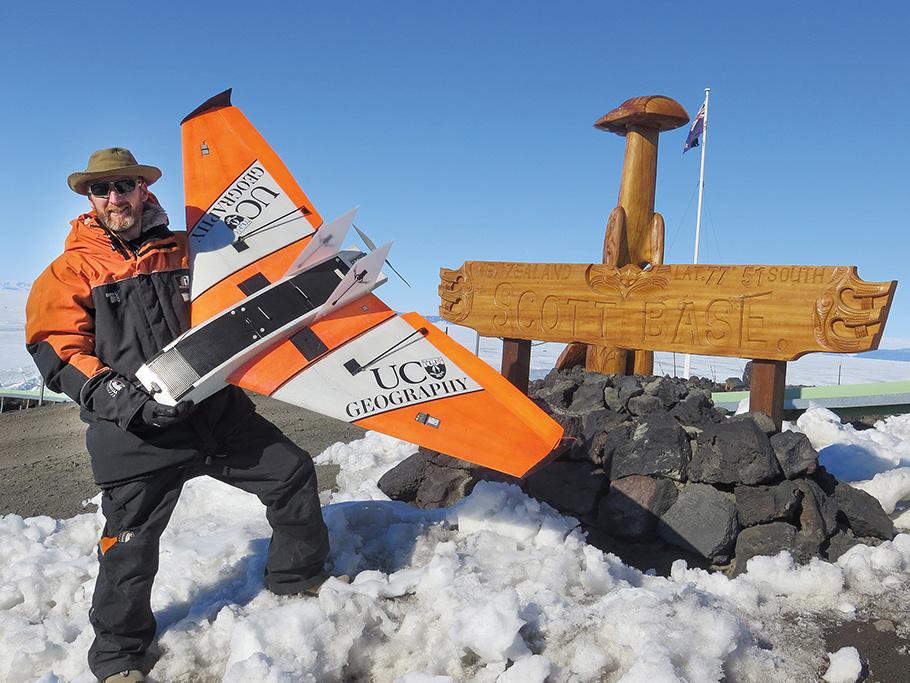 Paul Bealing holds up his custom-made fixed wing drone, dwarfed by the delta-shaped wingspan.
