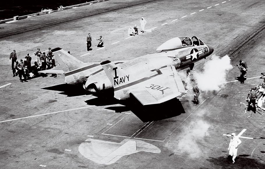 Steam rises from a catapult on the brink of launching a Cutlass from the deck of the USS Forrestal in 1956.