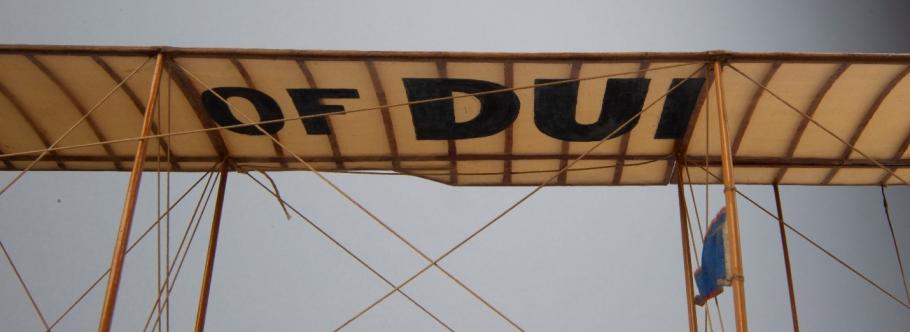 The canvas roof of a model airplane. The letter "OF DUI" are clear. 