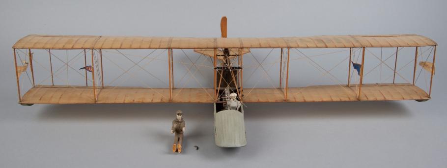 A model of a biplane with two dolls representing pilot and passenger. 
