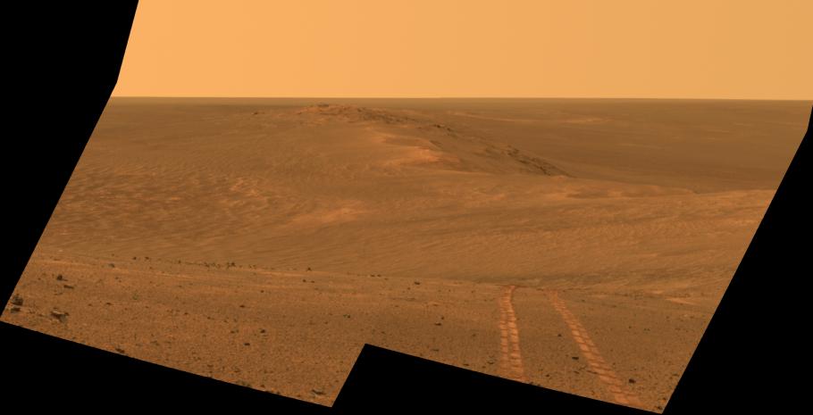 An artist's rendering of a dusty red landscape with hills or dunes. A set of two tire marks appears at the lower right side of the screen. 