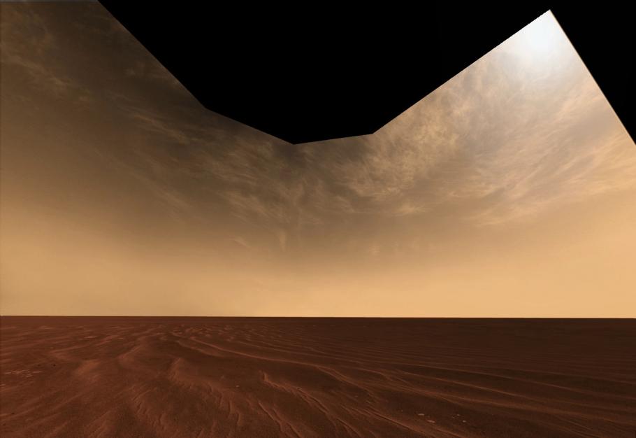 A flat, featureless plain. The ground looks like reddish sand and the sky is a pale orange and dotted with clouds.
